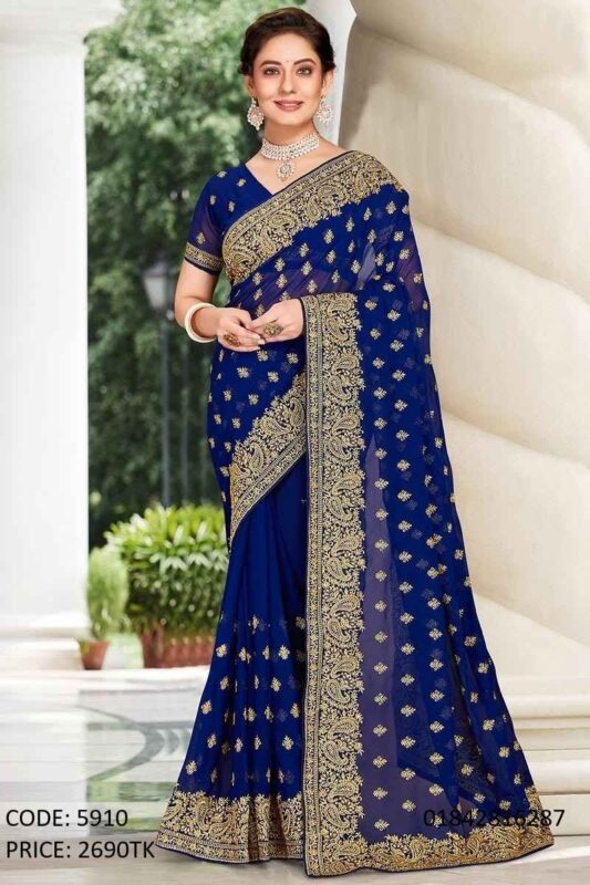 A full-length photo from image_0.png of a woman wearing a rich royal blue soft georgette saree, adorned with intricate gold paisley embroidery and shimmering gold sequins, styled for a party. She is standing outdoors with a graceful pose.