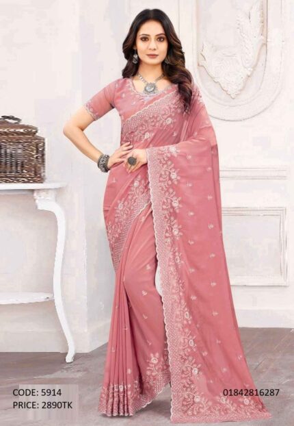 A woman wearing a light pink soft georgette saree featuring intricate embroidery and sequence work on the border and body.